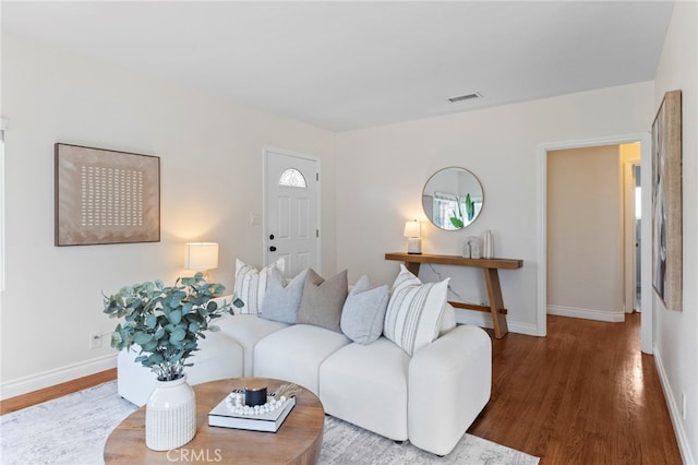 living room with visible vents, wood finished floors, and baseboards