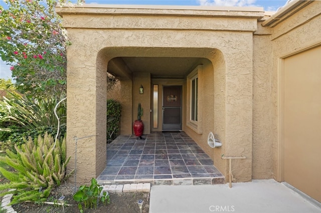 entrance to property featuring stucco siding