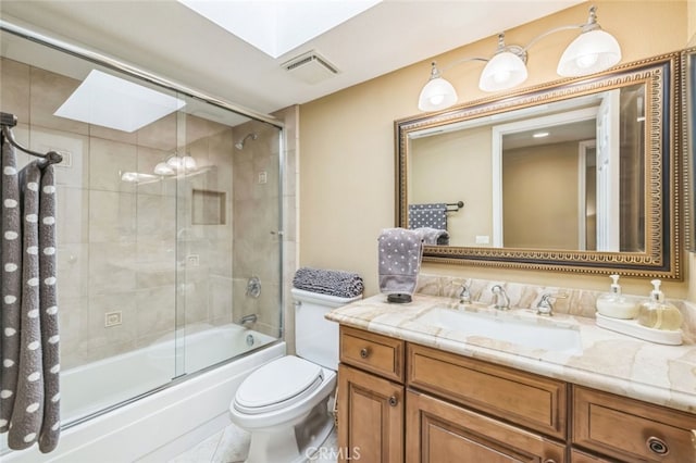 full bathroom with a skylight, bath / shower combo with glass door, vanity, and toilet