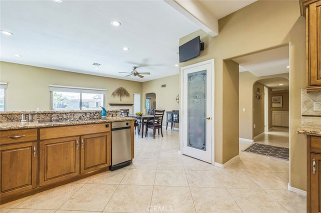 kitchen with light stone countertops, light tile patterned floors, and ceiling fan