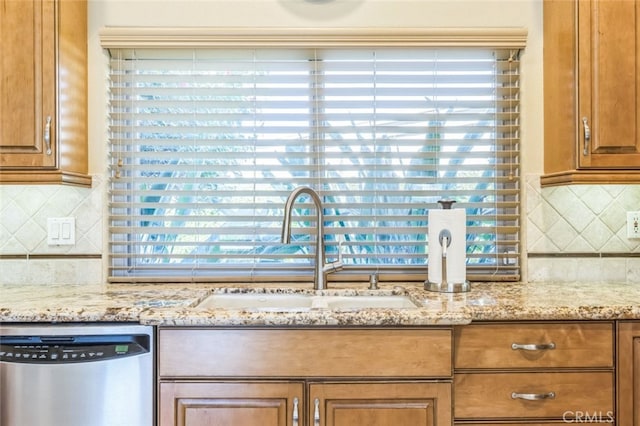 kitchen featuring light stone counters, sink, tasteful backsplash, and dishwasher