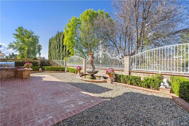 view of yard with exterior kitchen, fence, and a patio area