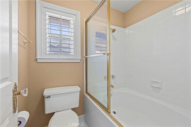 full bath featuring shower / bath combination with glass door and toilet