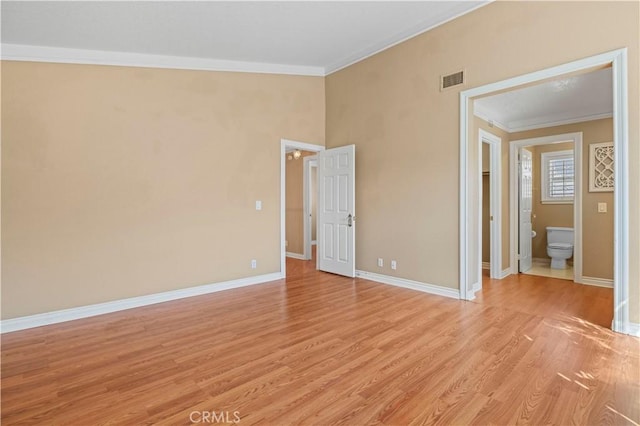 unfurnished bedroom with baseboards, crown molding, and light wood finished floors