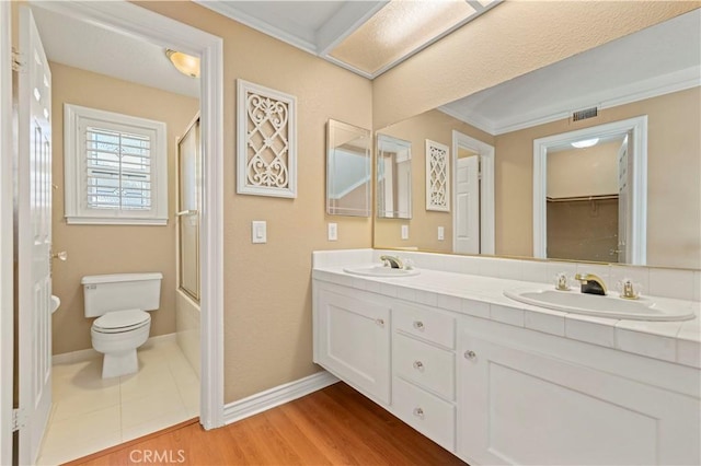 bathroom featuring wood finished floors, toilet, visible vents, and a sink