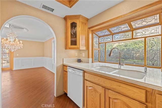 kitchen featuring visible vents, arched walkways, a sink, light countertops, and dishwasher