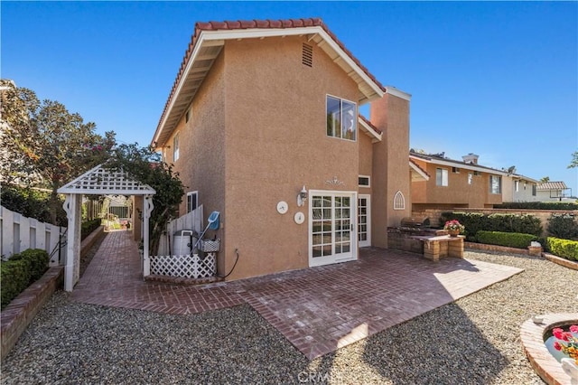 back of property with stucco siding, area for grilling, fence, a gazebo, and a patio area