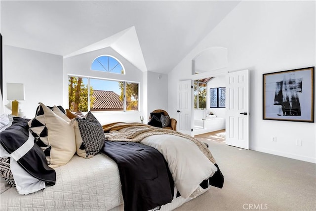 carpeted bedroom with ensuite bathroom, high vaulted ceiling, and baseboards