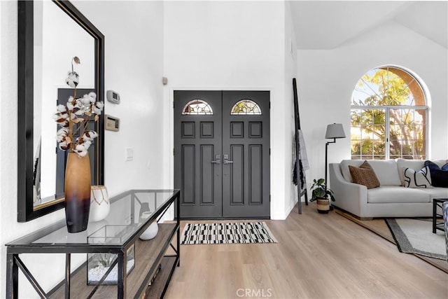 foyer featuring lofted ceiling and light wood finished floors