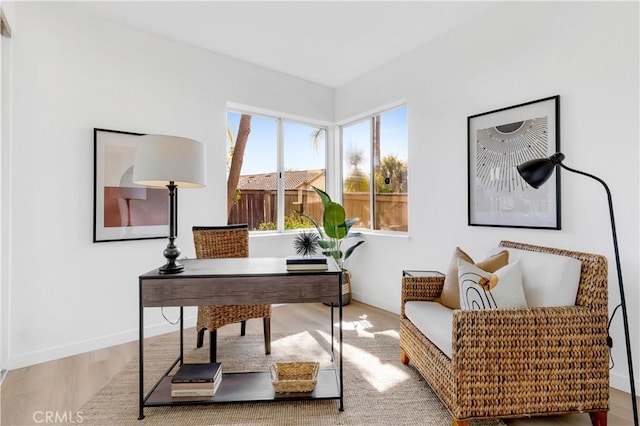 home office with baseboards and wood finished floors