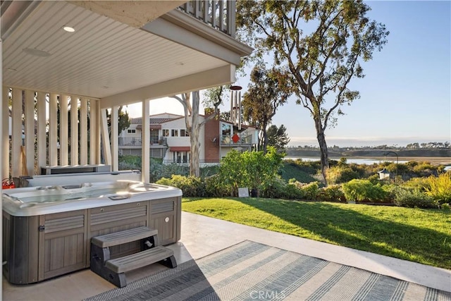 view of patio with a water view and a hot tub