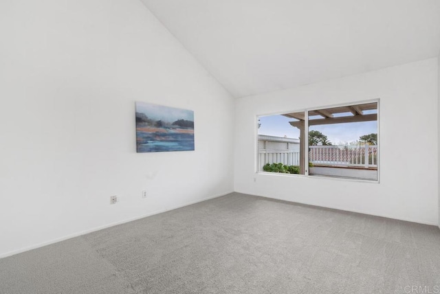 carpeted empty room with high vaulted ceiling