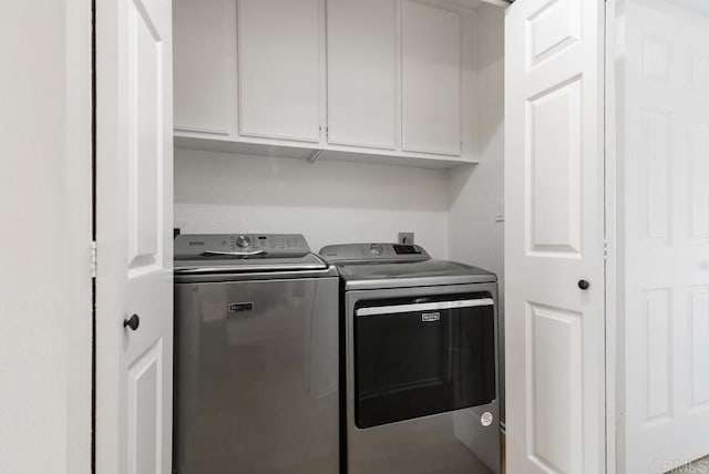 laundry room featuring independent washer and dryer and cabinets