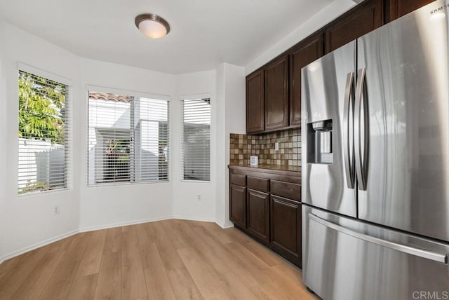 kitchen featuring dark brown cabinetry, stainless steel fridge with ice dispenser, tasteful backsplash, and light wood-type flooring