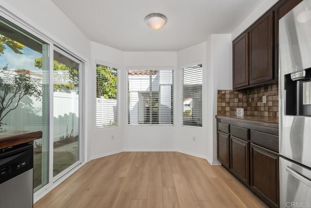 kitchen with stainless steel appliances, tasteful backsplash, dark brown cabinets, and light wood-type flooring