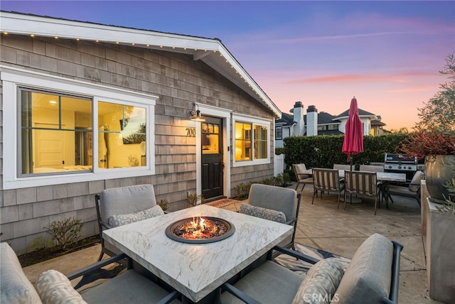 patio terrace at dusk with a grill and an outdoor fire pit