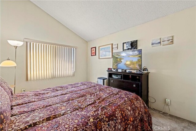 carpeted bedroom featuring a textured ceiling and lofted ceiling