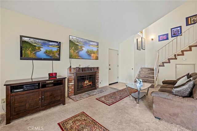 living area with stairs, carpet, and a fireplace