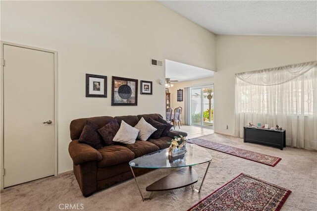 living area featuring ceiling fan, visible vents, carpet, and high vaulted ceiling