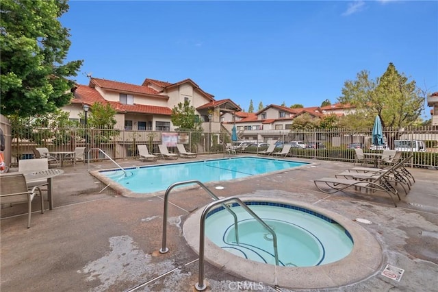 view of swimming pool with a community hot tub and a patio area