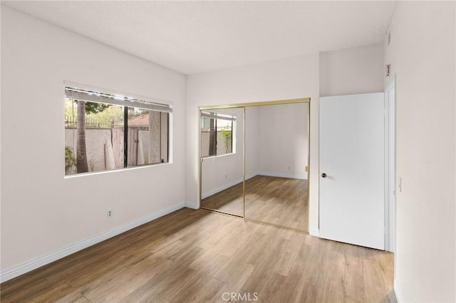 unfurnished bedroom with a closet and hardwood / wood-style floors