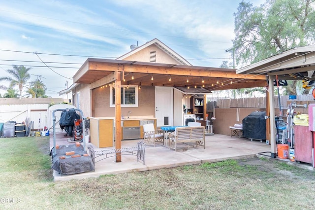 rear view of property with a lawn, a patio area, an outdoor hangout area, and sink