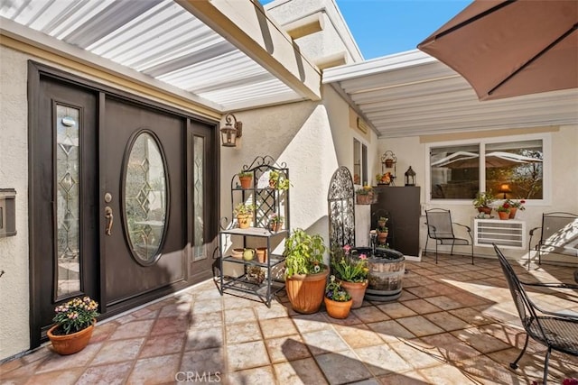 doorway to property with a patio area and stucco siding