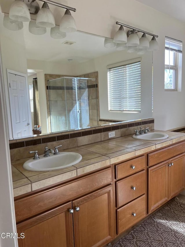 bathroom featuring vanity and a shower with shower door