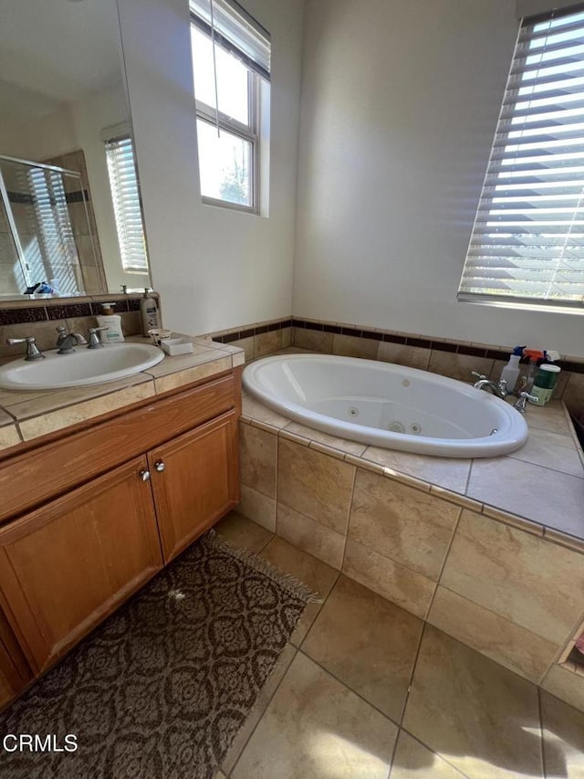 bathroom with tile patterned flooring, vanity, and separate shower and tub