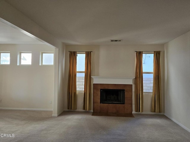 unfurnished living room with a fireplace and light carpet