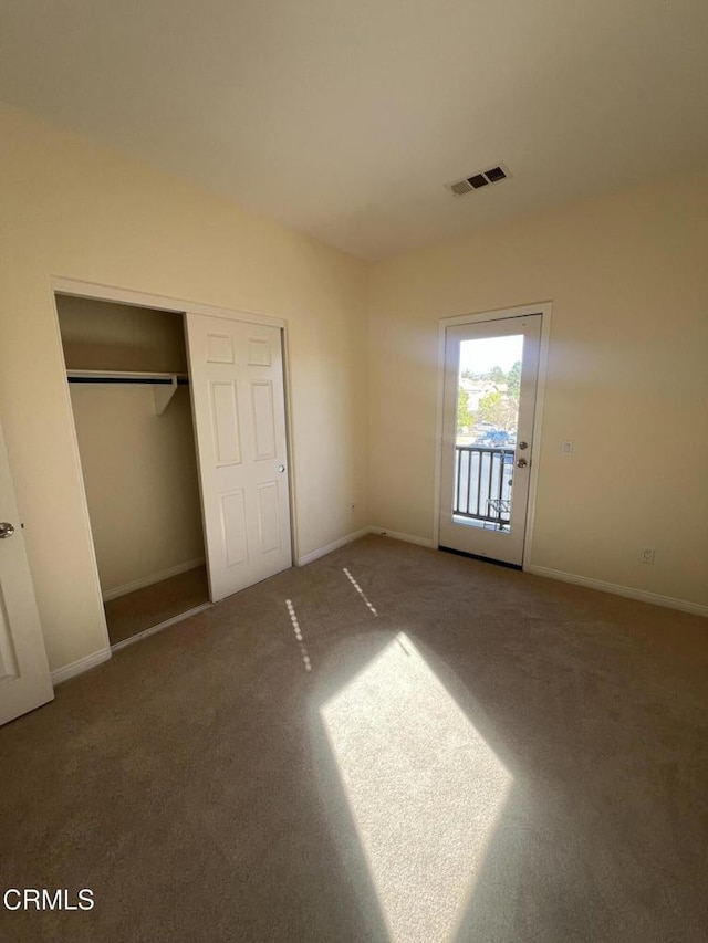 unfurnished bedroom featuring carpet floors, access to outside, and a closet