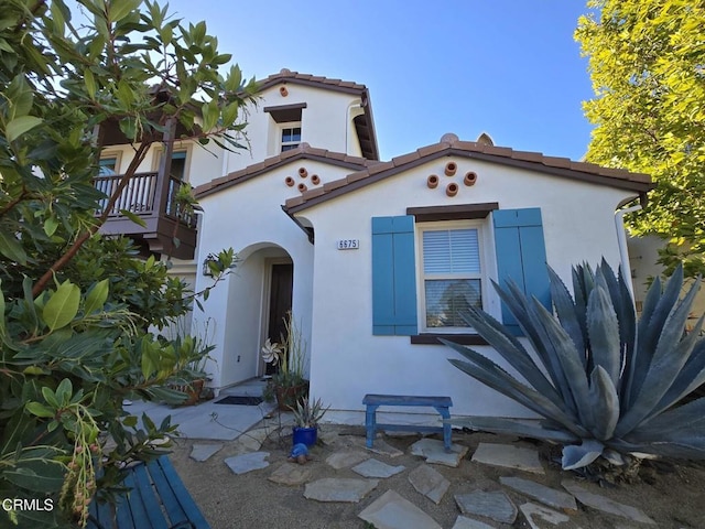 mediterranean / spanish home with a tiled roof and stucco siding