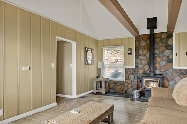 living room with lofted ceiling, hardwood / wood-style floors, and a wood stove