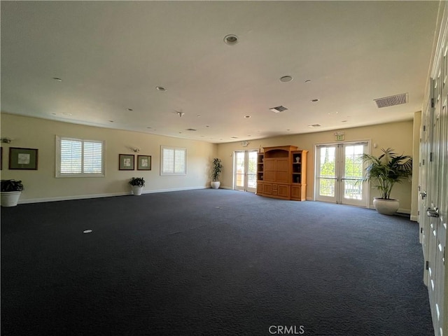 unfurnished living room with french doors, carpet, visible vents, and baseboards