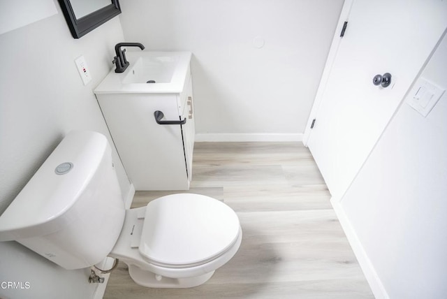 bathroom with vanity, toilet, and hardwood / wood-style floors