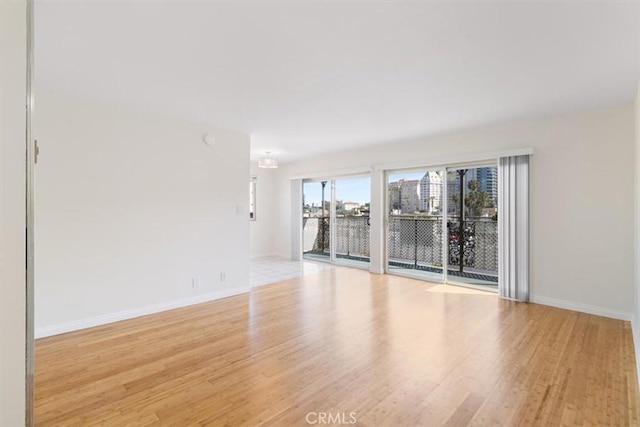 unfurnished room with wood finished floors and baseboards