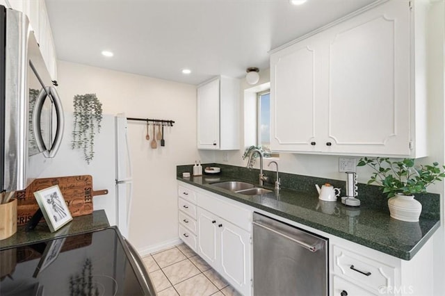 kitchen featuring light tile patterned floors, a sink, white cabinetry, and stainless steel appliances