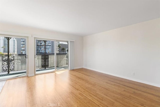 unfurnished room featuring light wood-style floors and baseboards