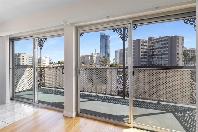 doorway featuring wood finished floors, a city view, and baseboards