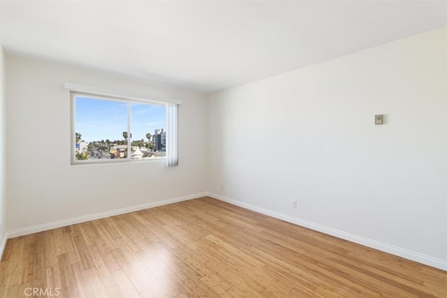 unfurnished room featuring light wood-style flooring and baseboards