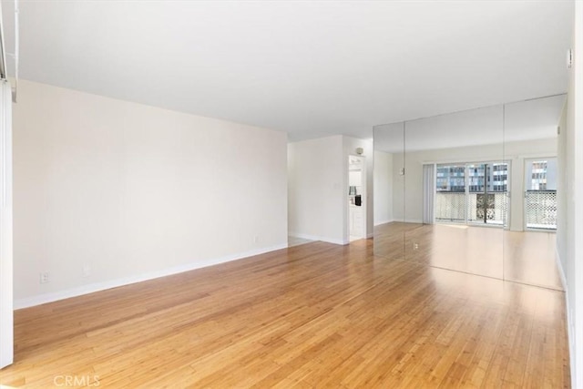 unfurnished living room featuring baseboards and light wood-style flooring