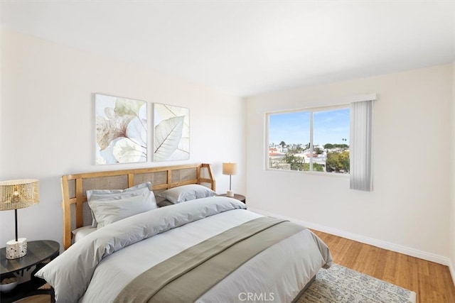 bedroom with baseboards and wood finished floors