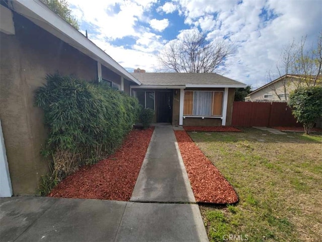 view of exterior entry with a lawn