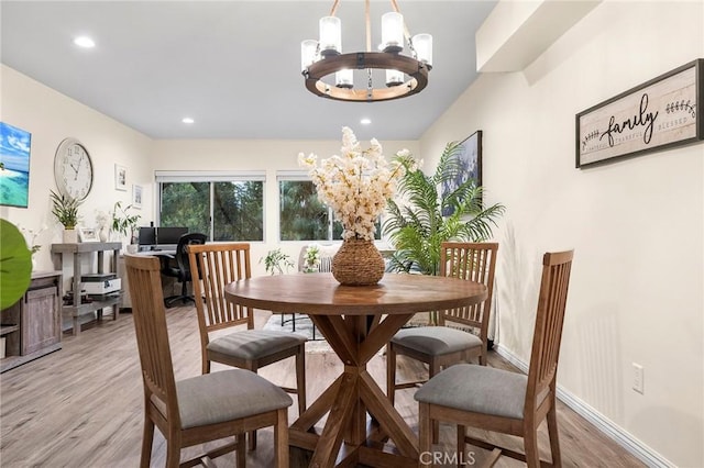 dining area with a chandelier and light wood-type flooring