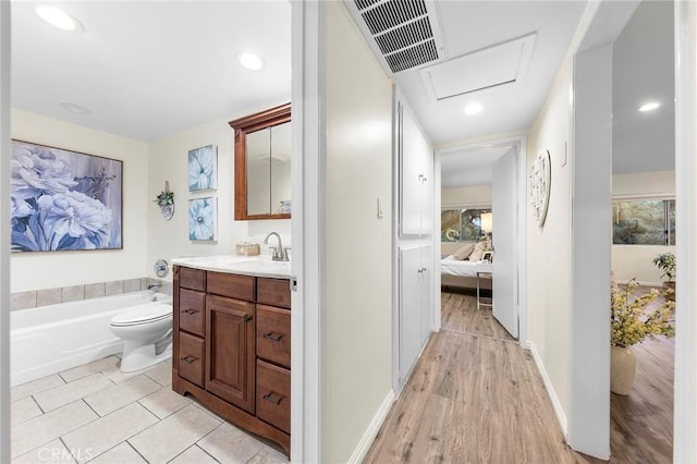 bathroom with vanity, a tub, and toilet