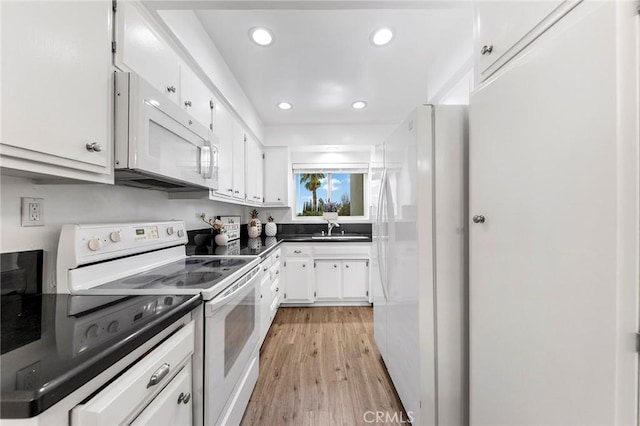 kitchen with white cabinetry, sink, white appliances, and light hardwood / wood-style floors