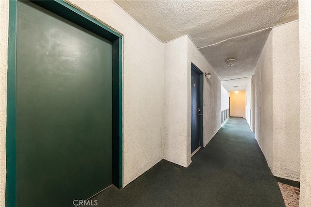 hall featuring a textured ceiling