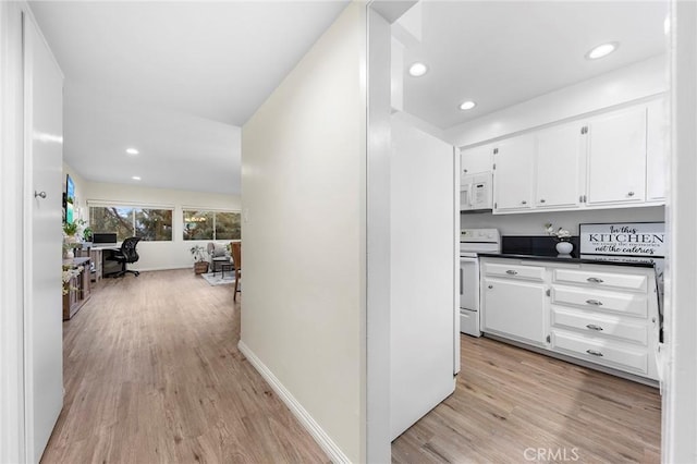 kitchen with white cabinetry, white appliances, and light hardwood / wood-style floors