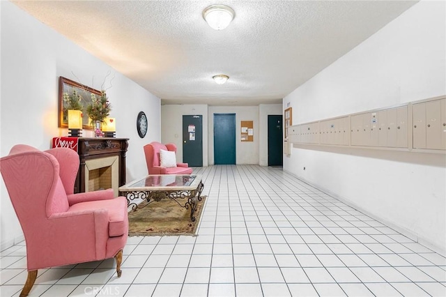 sitting room featuring mail boxes, a textured ceiling, and light tile patterned floors