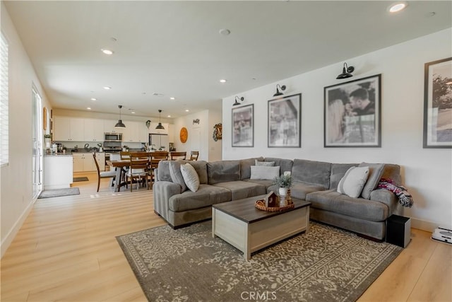 living room with baseboards, light wood-style flooring, and recessed lighting